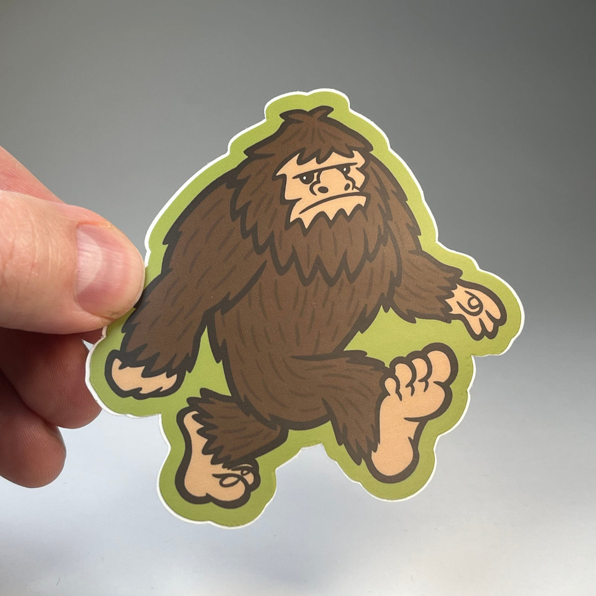 Hand holding the Bigfoot Cute cryptid sticker
