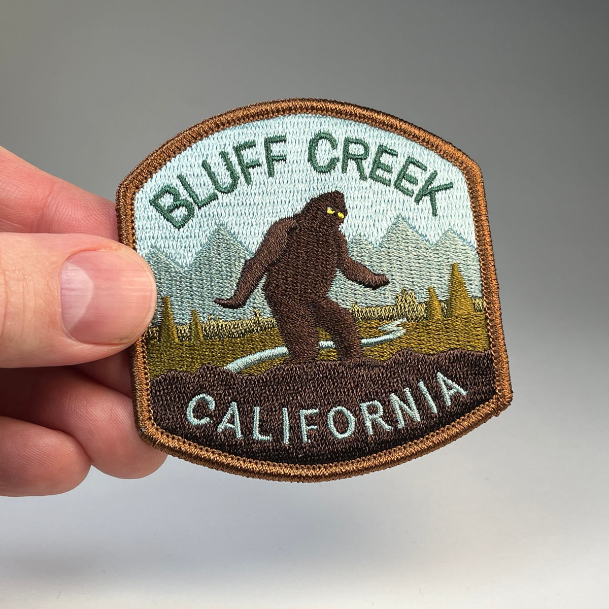 Hand holding the Bluff Creek California Bigfoot cryptid travel patch