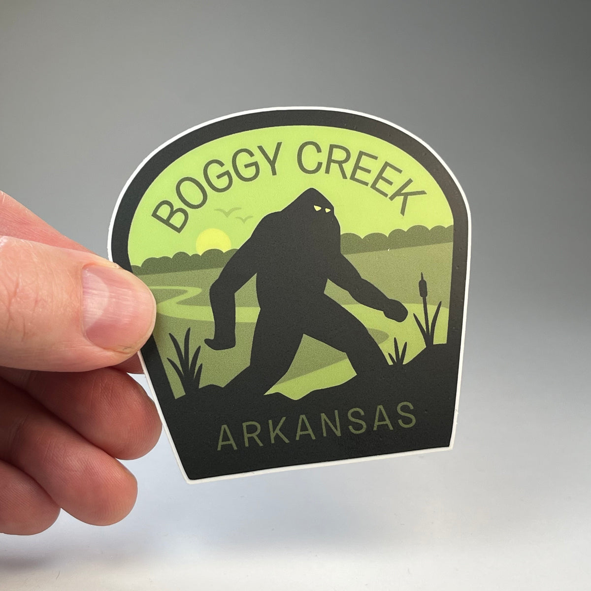 Hand holding the Boggy Creek Arkansas Monster cryptid travel sticker