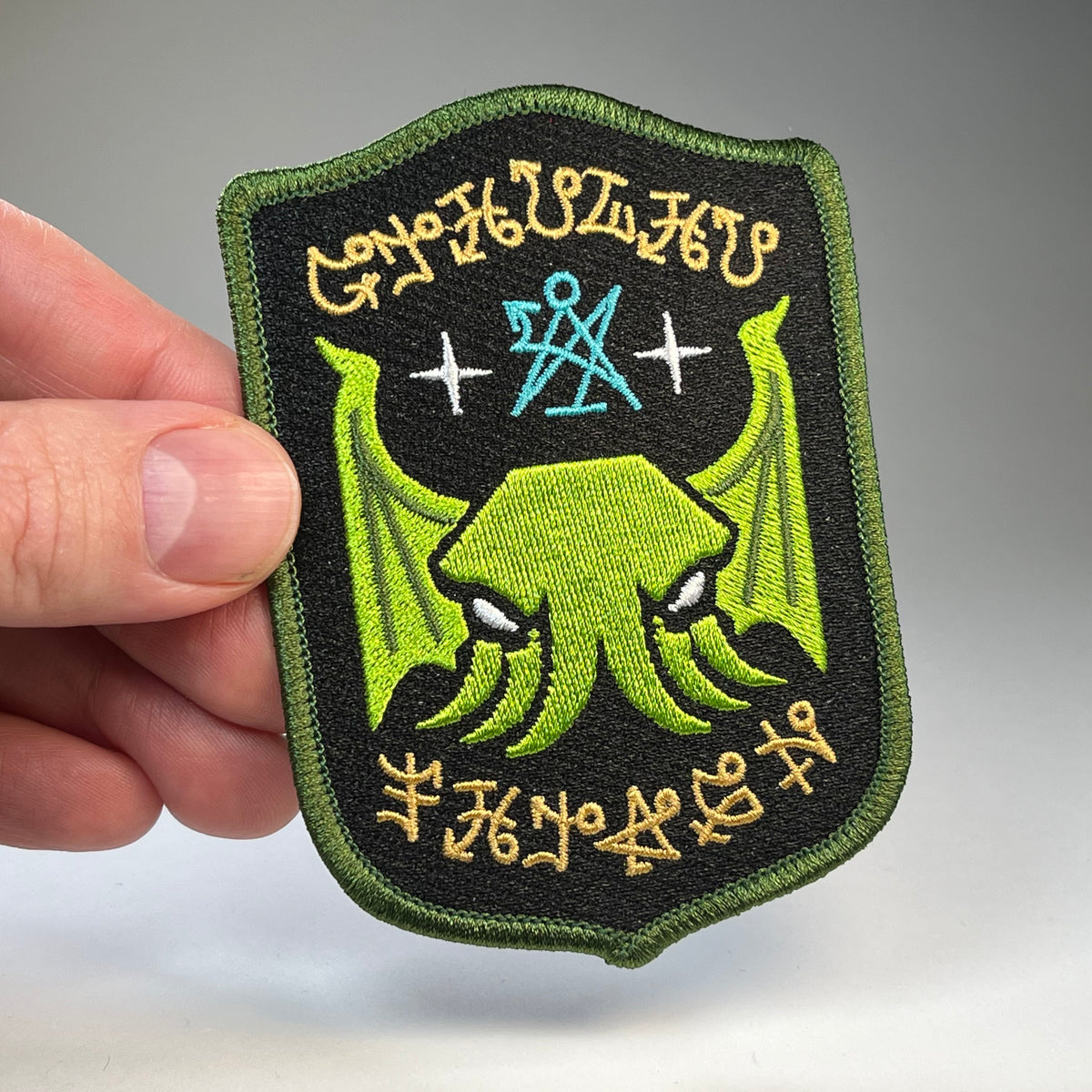 Hand holding the Cthulhu Fhtagn embroidered patch
