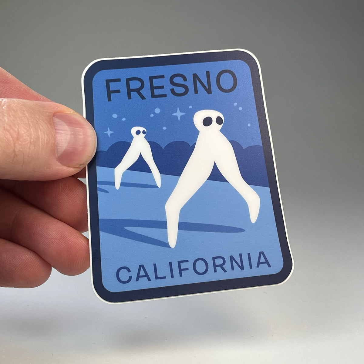 Hand holding the Fresno California Nightcrawlers cryptid travel sticker