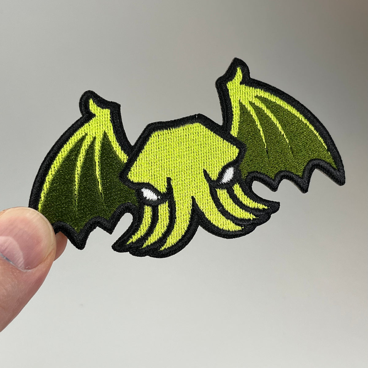 Hand holding the Winged Cthulhu Embroidered Patch