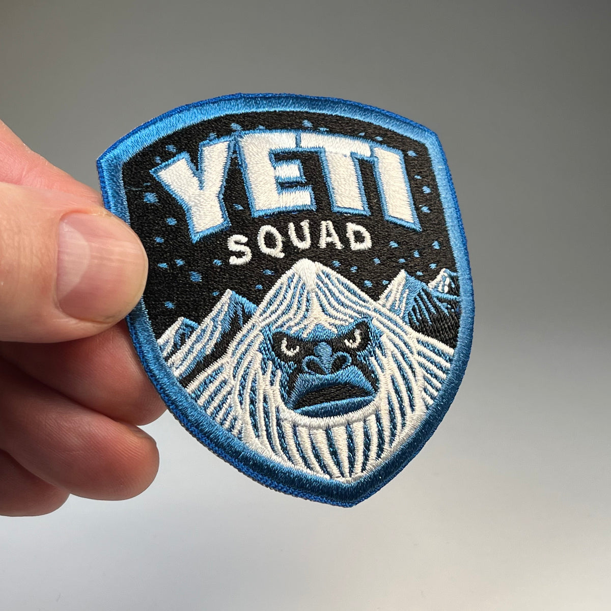 Hand holding the Yeti Squad cryptid military badge embroidered patch