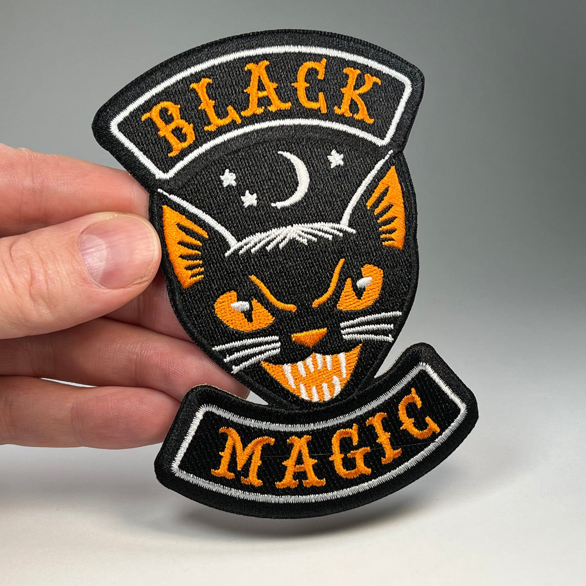 Hand holding the Black Magic cat Halloween biker embroidered patch