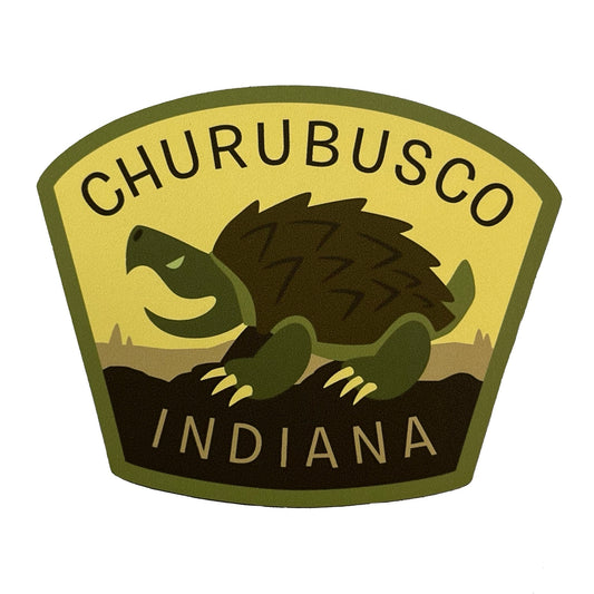 Logo of Churubusco, Indiana with a turtle illustration on a yellow background