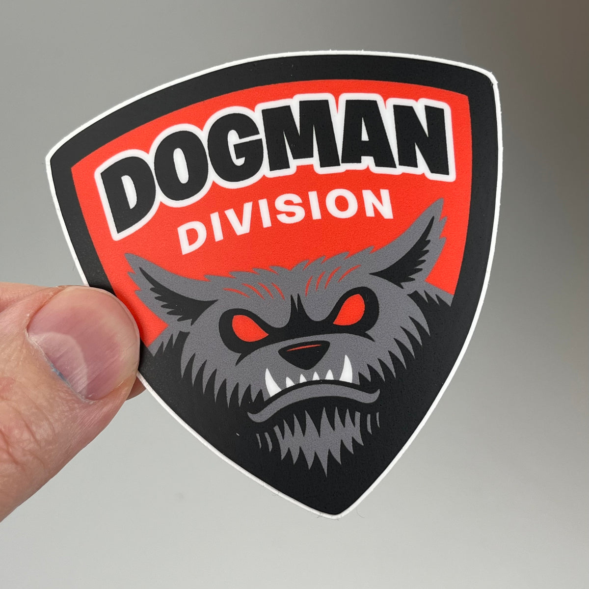 Hand holding the Dogman Division Sticker
