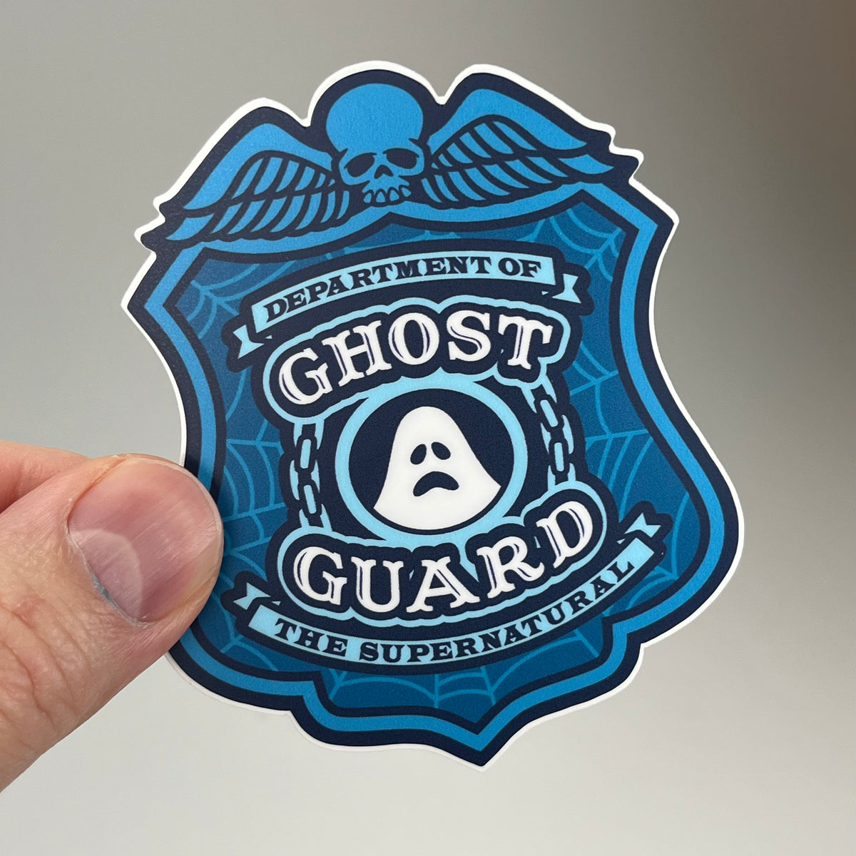 Hand holding the Ghost Guard Police Badge Sticker