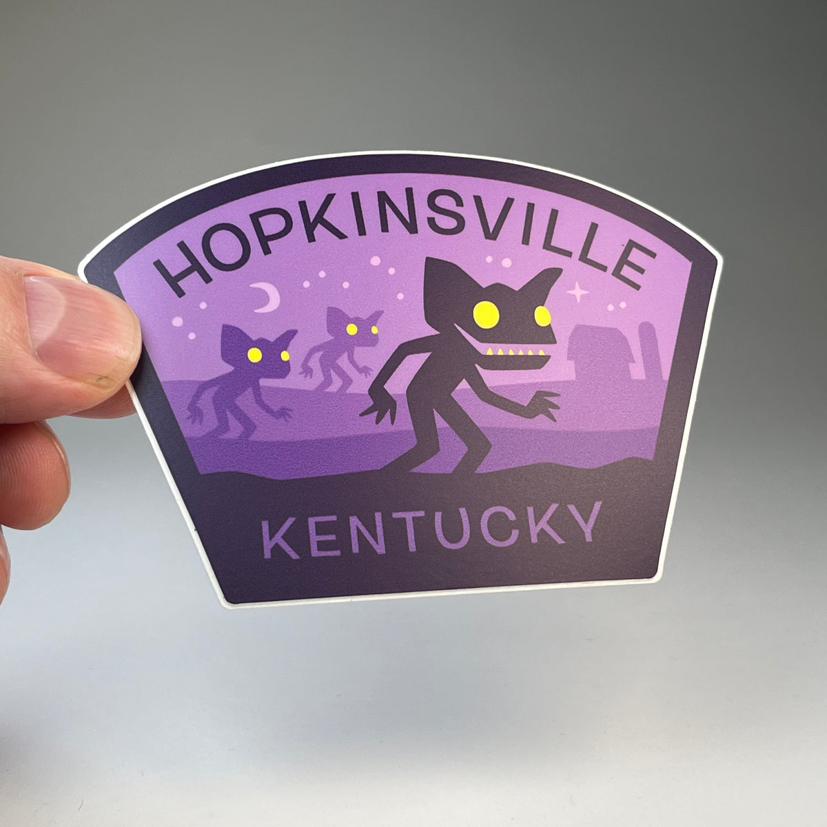 Hand holding the Hopkinsville Kentucky Goblins cryptid travel sticker