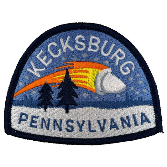 Embroidered patch with 'Kecksburg Pennsylvania' text and flaming, crashing acorn-shaped UFO design.