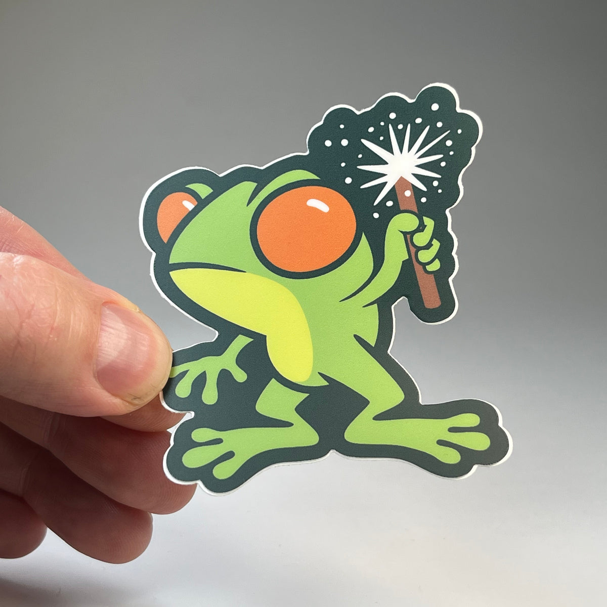 Hand holding the Loveland Frogman Cute cryptid sticker