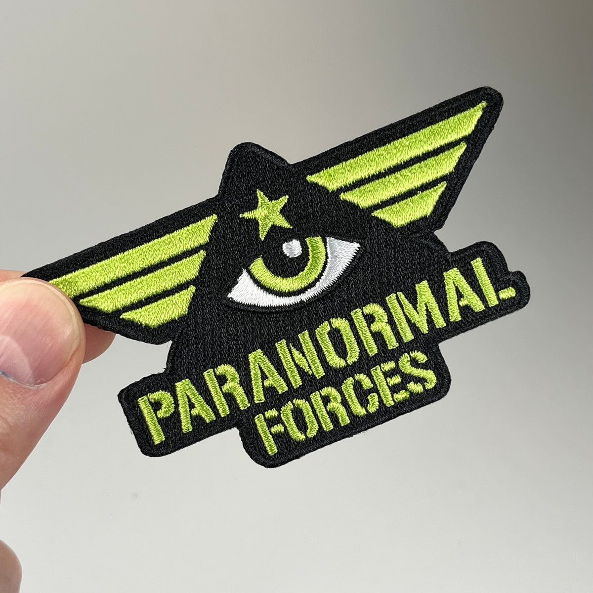 Hand holding the Paranormal Forces Embroidered Patch