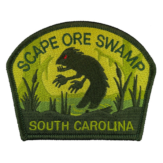 Embroidered patch with a Lizardman cryptid creature and text 'Scape Ore Swamp, South Carolina' on a green background