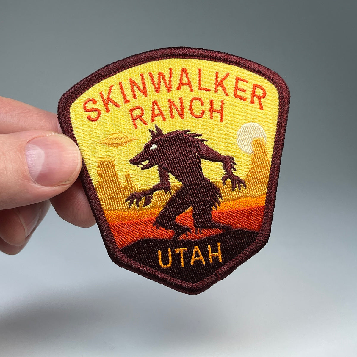 Hand holding the Skinwalker Ranch Utah cryptid travel patch