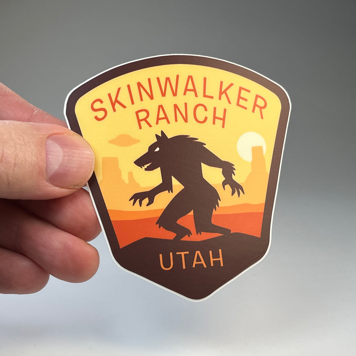 Hand holding the Skinwalker Ranch Utah cryptid travel sticker