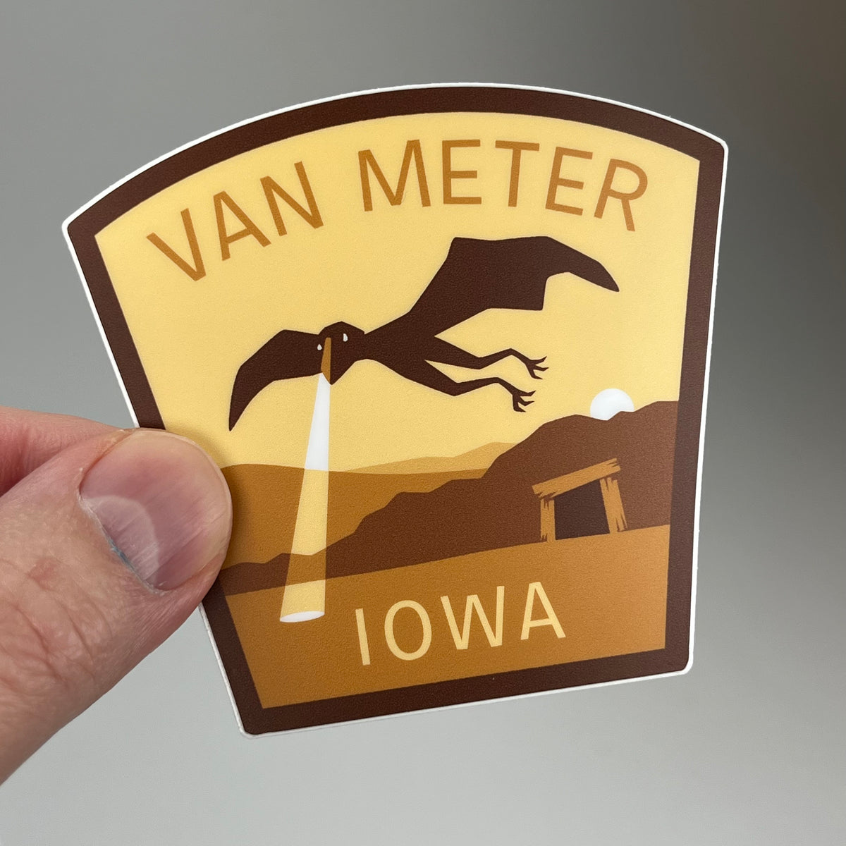 Hand holding the Van Meter Iowa Travel Sticker