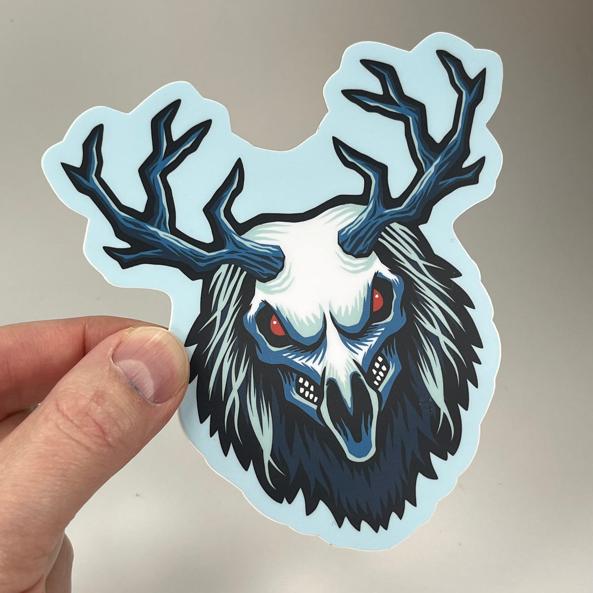 Hand holding the Wendigo Head Sticker