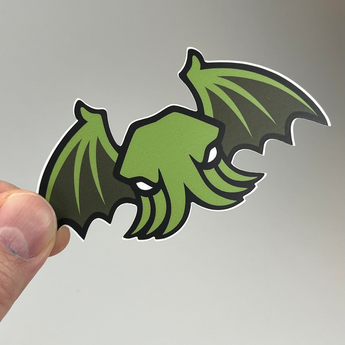 Hand holding the Winged Cthulhu Sticker