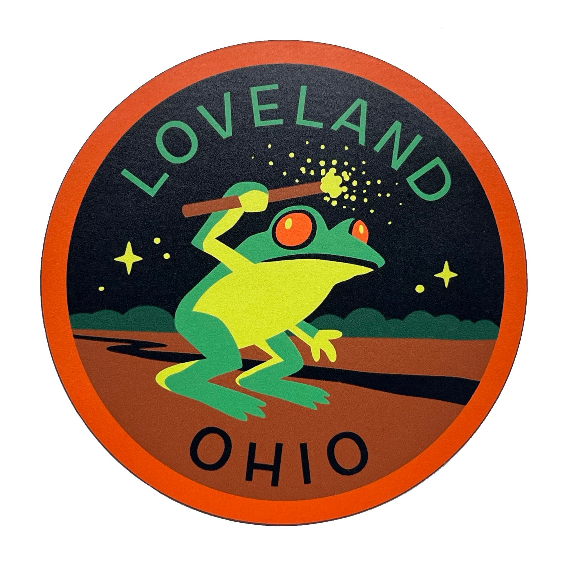 Circular magnet with a green frog holding a sparking wand, surrounded by stars, with 'Loveland Ohio' text.